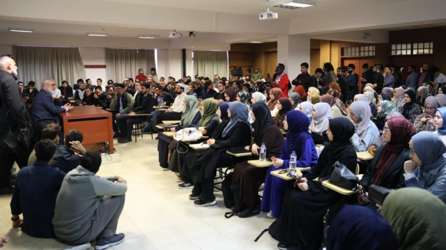Protestonun yapıldığı salonda haremlik selamlık şeklinde oturan kadın ve erkek öğrenciler, Nureddin Yıldız'ın konuşmasını dinliyor