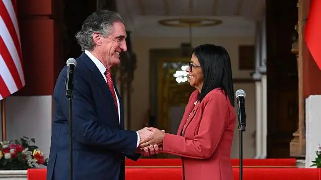 La presidenta interina de Venezuela, Delcy Rodríguez, estrecha la mano del secretario del Interior de EE. UU., Doug Burgum.