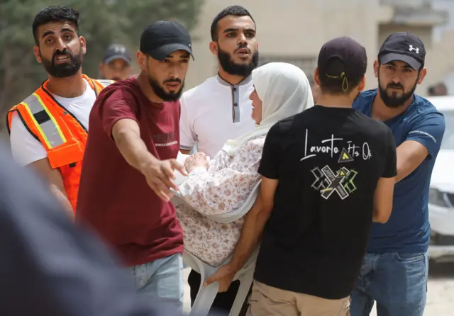 فلسطينيون يحملون سيدة على كرسي أثناء إخلاء منزلها في مداهمة إسرائيلية لمخيم جنين بالضفة الغربية المحتلة، في 1 سبتمبر/أيلول 2024