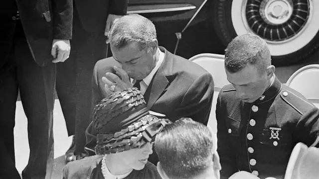 Joe DiMaggio cabizbajo, acompañado de su hijo, durante el funeral de Marilyn Monroe el 14 de agosto de 1962