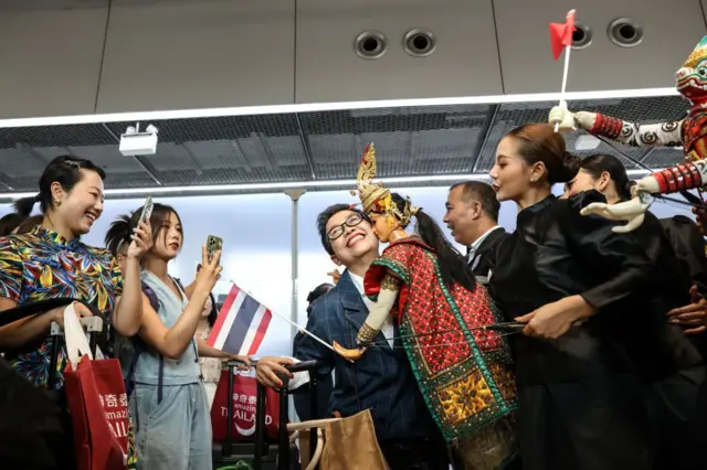 Visitors pose for photographs during an event to welcome inbound tourists from China at Suvarnabhumi Airport in Bangkok, Thailand, on Monday, Sept. 25, 2023.