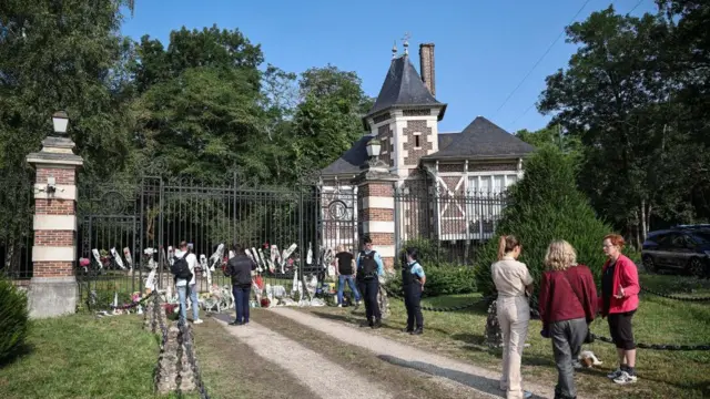訃報に接して多くのファンが邸宅の門に花束を供えた（19日、フランス・ドゥシー）