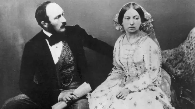 شاهزاده آلبرت کنار ملکه ویکتوریا نشسته کاغذی لوله شده در دست دارد، یک دستش را پشت ملکه گذاشته به او نگاه می‌کند