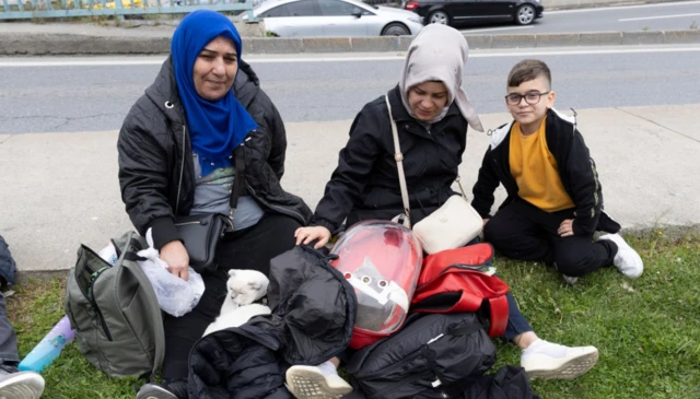 İstanbul'da halen çok sayıda kişi yeni bir deprem korkusuyla sokakta bekliyor. İki kadın ve bir çocuk, açık çim bir alanda evcil kedileriyle birlikte bekliyor.
