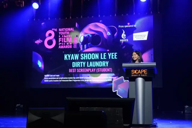 ဆုလက်ခံယူတဲ့ စင်မြင့်ပေါ်က ဒါရိုက်တာ ကျော်ရွှန်းလဲ့ရည်