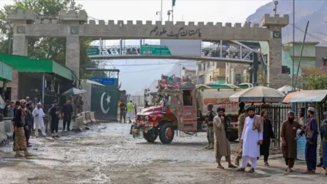 تصویری از گذرگاه تورخم میان پاکستان و افغانستان. یک موتر باربری، شماری از رانندگان و نظامیان در تصویر دیده‌ می‌شوند.