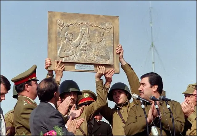  نجیب‌الله، در ۱۷ اکتبر ۱۹۸۶ در جریان یک رژه نظامی در کابل، در حال تشویق در کنار سربازان شوروی و افغان ایستاده و افسران شوروی نیز لوح یادبود، دوستی افغانستان و شوروی را در دست دارند 