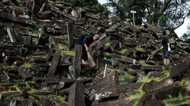 Beberapa orang sedang membersihkan lokasi Gunung Padang.