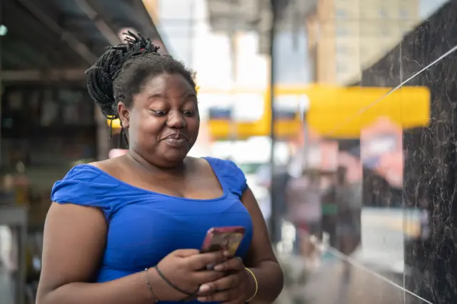 Big african woman dey use mobile phone