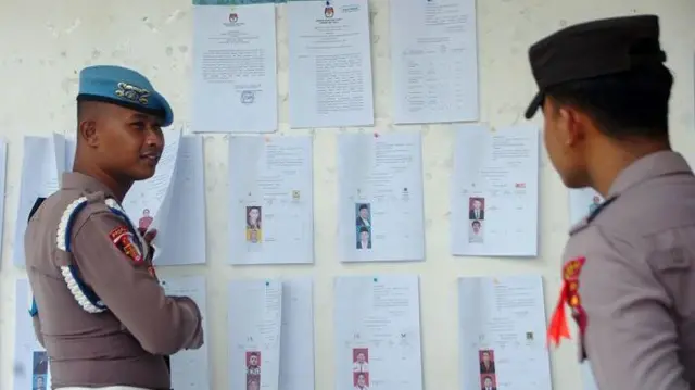 Personel kepolisian memperhatikan Daftar Calon Tetap (DCT) anggota DPRD Kabupaten Tegal saat pengumuman di KPU Kabupaten Tegal, Jawa Tengah, Sabtu (4/11/2023).