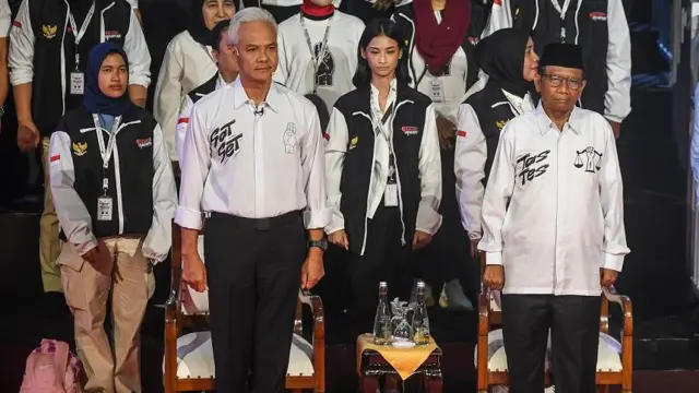 Pasangan Capres-Cawapres nomor urut tiga Ganjar Pranowo (depan kiri) dan Mahfud MD (depan kanan) berdiri sebelum debat perdana Capres dan Cawapres 2024 di Gedung KPU, Jakarta, Selasa (12/12/2023).