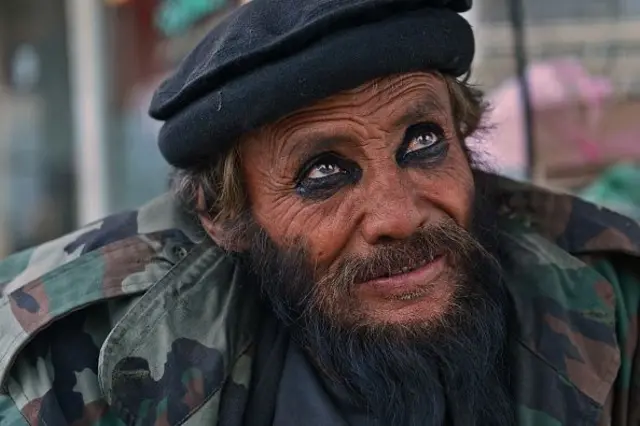 یو افغان، چې په عکس کې یې دودیز رانجه لګولي، د ۲۰۱۳ کال د فبروري پر ۲۴مه په کابل کې یوې کوڅې ته ګوري.