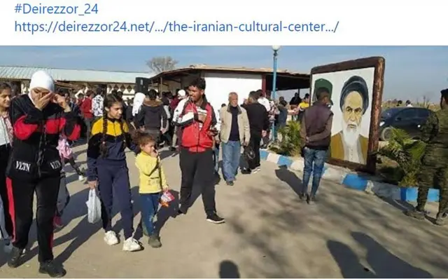 جمعی از مردم در خیابان همراه با تصویری از خمینی