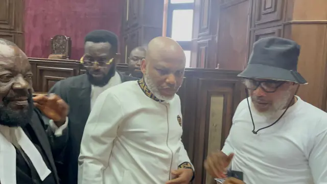Nnamdi Kanu (middle) with his brother Emmanuel Kanu (in cap) and his lawyers inside a courtroom at the Federal High Court, Abuja, Sept. 2024