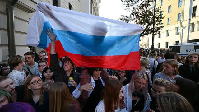 Rus bayrağı taşıyan Yabloko partisi destekçileri, partinin Devlet Duma seçimlerinden çıkarılmasını amaçlayan bir davanın duruşması sırasında Yüksek Mahkeme binasının önünde duruyor.