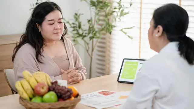 mulher conversando com profissional de saúde
