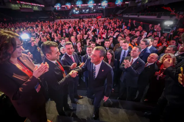 Özgür Özel sahneye çıkarken parti yetkililerinin elini sıkıyor