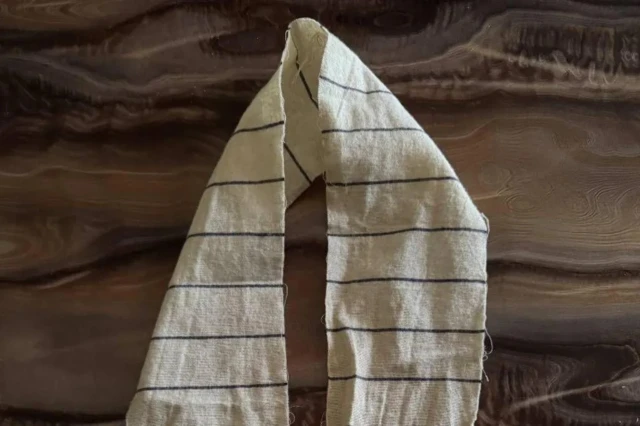 Длинная полоска белой ткани в черную полосочку