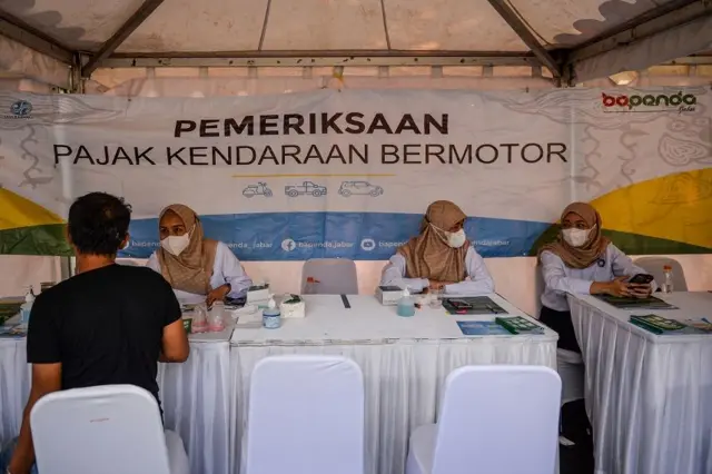 Petugas melayani warga yang akan membayar pajak kendaraan saat operasi pemeriksaan pajak kendaraan bermotor, Rabu (13/11.