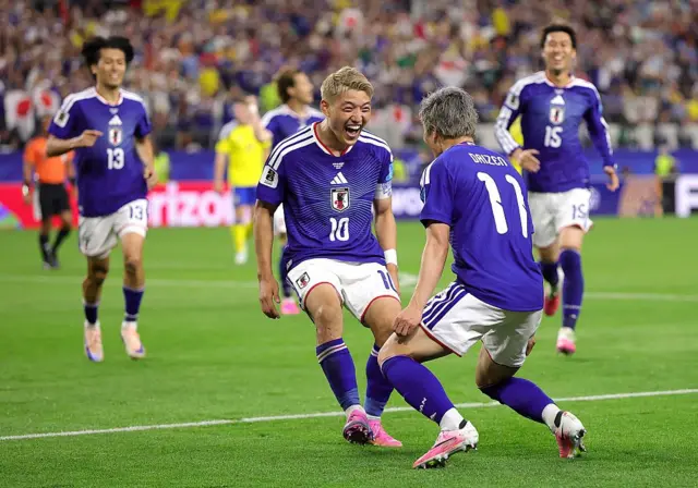 Daizen Maeda (nomor punggung 11) merayakan gol dengan Ritsu Doan (nomor punggung 10) 