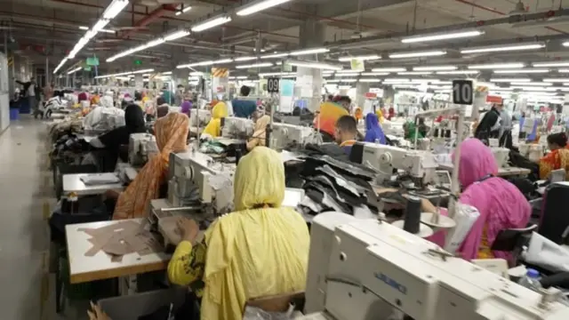 একটি পোশাক কারখানায় অনেকগুলো মেশিনে কাজ করছেন শ্রমিকরা