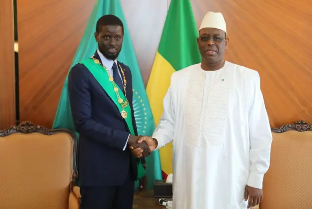 Le président sénégalais nouvellement élu, Bassirou Diomaye Faye (à gauche), serre la main de l'ancien président sénégalais Macky Sall (à droite) après avoir prêté serment devant le Conseil constitutionnel à Dakar, au Sénégal, le 2 avril 2024.