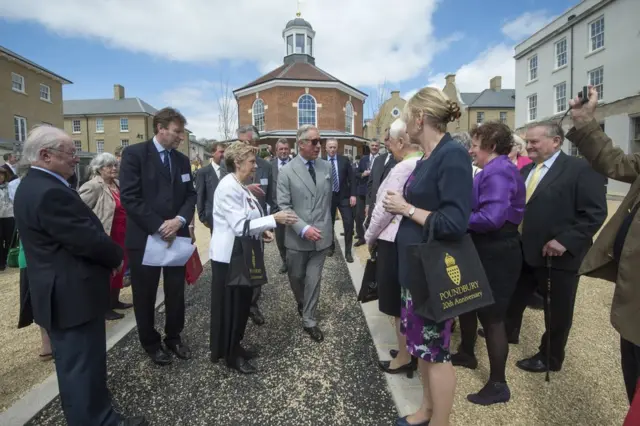 King Charles III walking around Poundbury and meeting residents.