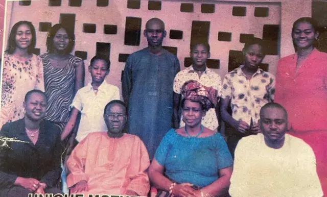 Family foto of di Ilobi's, di late Ijeoma wear black suit while late Nnenna wear red suit.