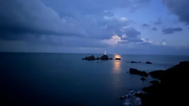 Пучина, у даљини светионик, а около су стене