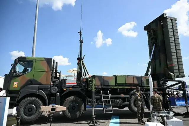 SAMP T füzesi kamuflaj renkli bir kamyona yüklü önünde iki asker duruyor.