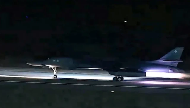 Un bombardier B-1 décollant d'une piste dans l'obscurité