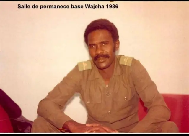 Mahamadou Sy, du temps où il servait son pays comme militaire assis sur un fauteuil rouge, le regard vers la caméra, une moustache et cheveux noirs avant son arrestation et sa détention au camp militaire d'Inal.