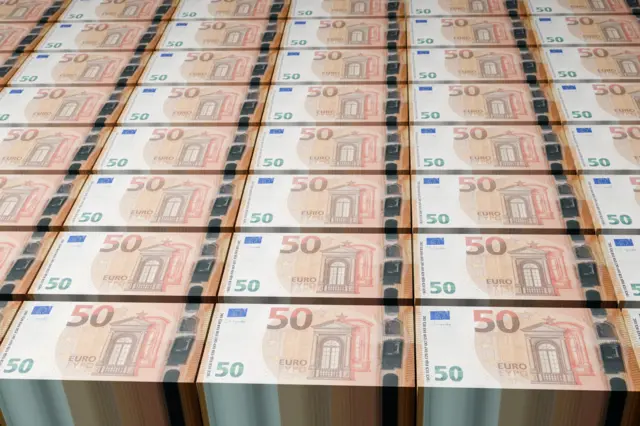 Стоси 50‑єврових банкнот формують рівні щільні ряди на великій поверхні.