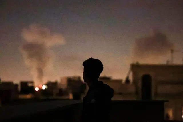 Hombre mira un bombardeo en Irán. 