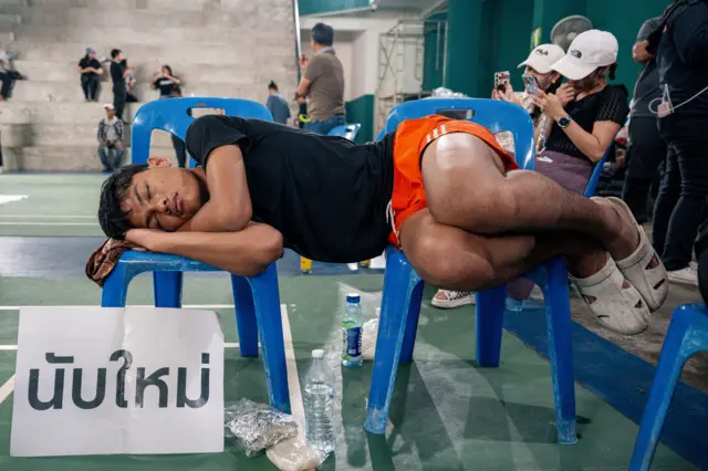 ประชาชนปักหลักค้างแรมที่สนามแบดมินตัน เทศบาลเมืองชลบุรี อ.เมือง จ.ชลบุรี เมื่อคืนวันที่ 9 ก.พ. เพื่อเฝ้าติดตามขอคำตอบให้มีการนับคะแนนใหม่ สส.ชลบุรี เขต 1 ใหม่