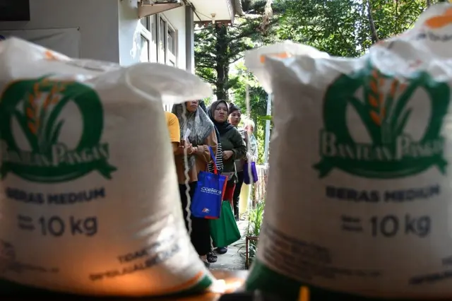 Sejumlah warga penerima bantuan antre saat penyaluran bantuan pangan beras sebanyak 20 kilogram di Kota Bogor, Jawa Barat, Kamis (31/07).