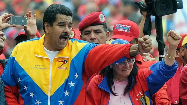 الرئيس الفنزويلي نيكولاس مادورو يشارك في مسيرة تقليدية بمناسبة عيد العمال في كاراكاس في الأول من مايو 2013 ويرتدي بدلة رياضية تحمل ألوان علم بلاده