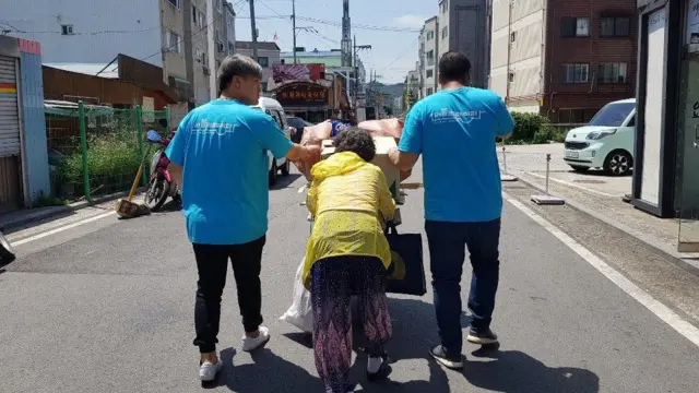 러블리페이퍼 청년 직원들이 폐지 수거 노인의 손수레를 함께 끌고 있다