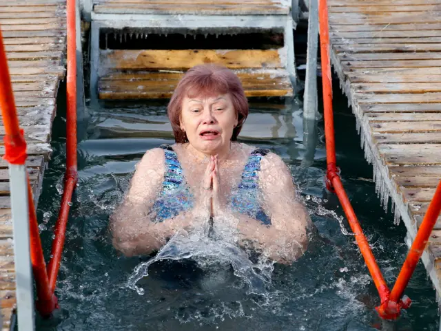 Православна верница се купа у реци у част Богојављања, у селу Воронцовка, око 10 километара од Бишкека, главног града Киргистана, 19. јануара 2026. Људи верују да купање у благословеној води током празника Богојављења јача њихов дух и тело.
