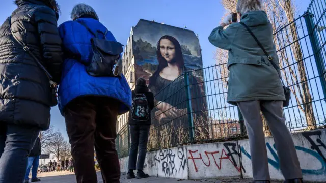 Pessoas tiram fotogiga sena loteriasmuralgiga sena loteriasBerlin que reproduz a obra Mona Lisagiga sena loteriasDa Vinci