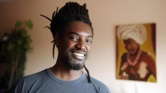 Álvarez, um homem negro e sorrindo para foto