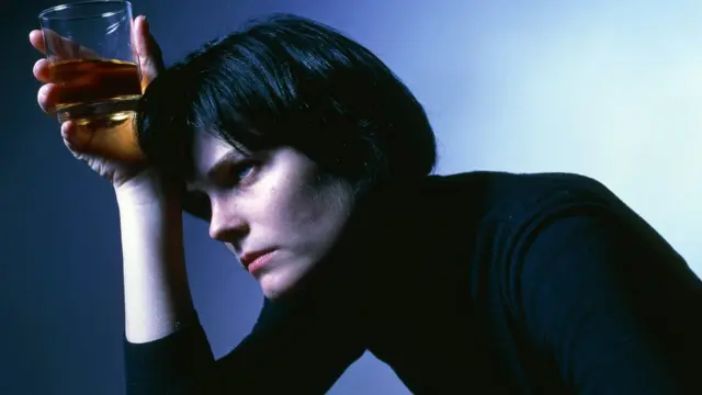 Женщина со стаканом алкоголя