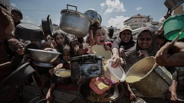 Палестинцы протягивают кастрюли к посудине с едой