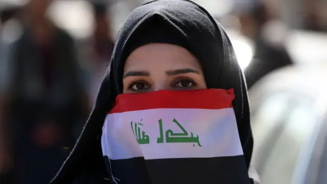 عراقية تتكمم بعلم بلادها