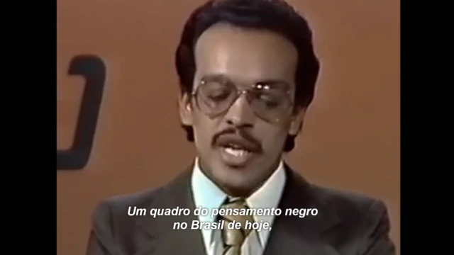 Paulo Roberto Leandroaposta milionaria bet365óculos, bigode fino e terno marrom. Numa legendaaposta milionaria bet365letras brancas, lê-se a fala do jornalista, que diz "Um quadro do pensamento negro no Brasilaposta milionaria bet365hoje"