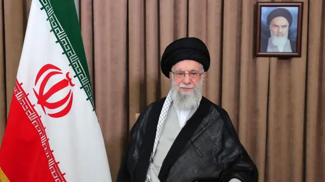 Ayetullah Ali Hamaney İran bayrağının yanında oturuyor