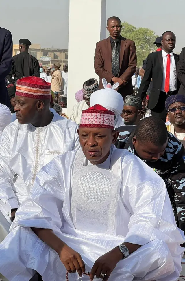 Govnor of Kano State, Abba Kabir Yusuf wear all white cloth wit red cap, e sitdown for ground for prayers.