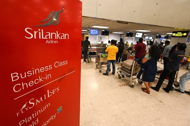 travellers stand in a queue at the check-in desk for SriLankan Airlines at the Colombo International Airport in Katunayake. - Dozens of state-owned Sri Lankan companies employing tens of thousands of people could be downsized or closed as part of an IMF bailout of the bankrupt country, with the country's airline top of the list for reform. - TO GO WITH SriLanka-economy-aviation-privatisation, FOCUS by Amal JAYASINGHE (Photo by Ishara S. KODIKARA / AFP) / TO GO WITH SriLanka-economy-aviation-privatisation, FOCUS by Amal JAYASINGHE (Photo by ISHARA S. KODIKARA/AFP via Getty Images)