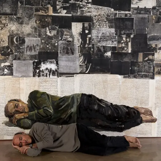 رضا دوست که در برابر تابلوییی از خودش دراز کشیده است