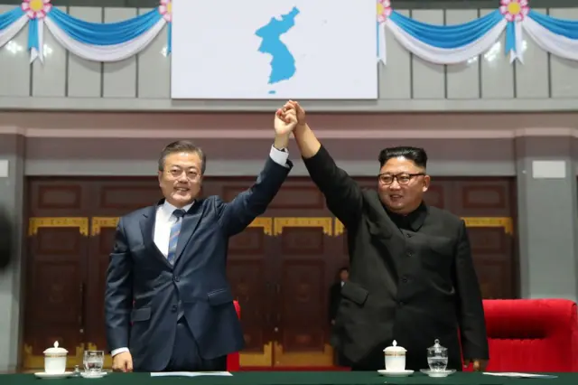Moon Jae-in y Kim Jong-un con los brazos unidos en alto
